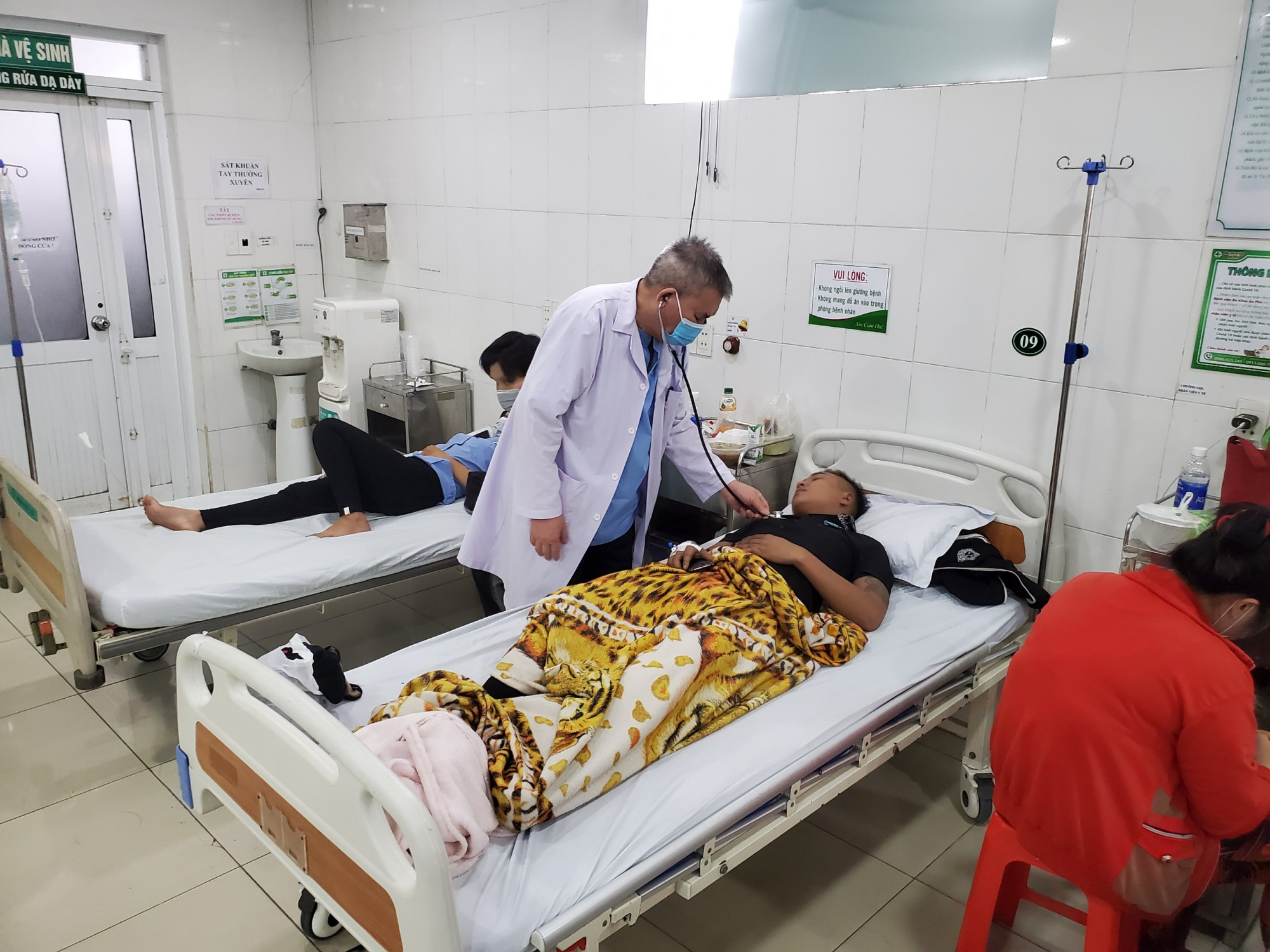 Thạc sĩ - Bác sĩ chuyên khoa cấp 2 Nguyễn Đình Đạt - Trưởng khoa Cấp cứu hồi sức bệnh viện An Phú đang thăm hỏi các nạn nhân. Ảnh: Nhật Linh