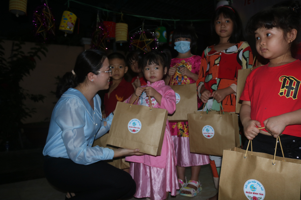 Bà Huỳnh Đặng Hà Tuyên - Chủ tịch Hội LHPN quận Bình Tân - tặng quà cho các em. 