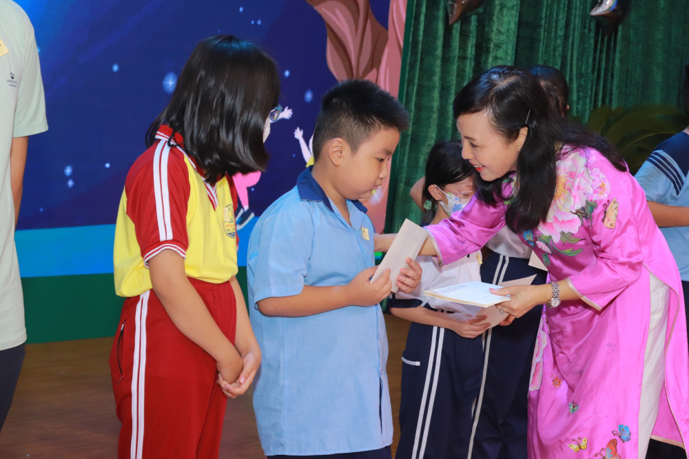 Bà Nguyễn Thị Kim Tiến, Nguyên bộ trưởng Bộ Y tế trao quà cho trẻ em khó khăn trong chương trình Vầng trăng yêu thương do Hội LHPN huyện phối hợp các đơn vị tổ chức tối 9/9/2022.