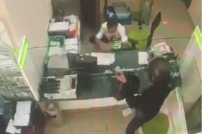 Hình ảnh đối tượng cầm súng đe dọa cướp ngân hàng.