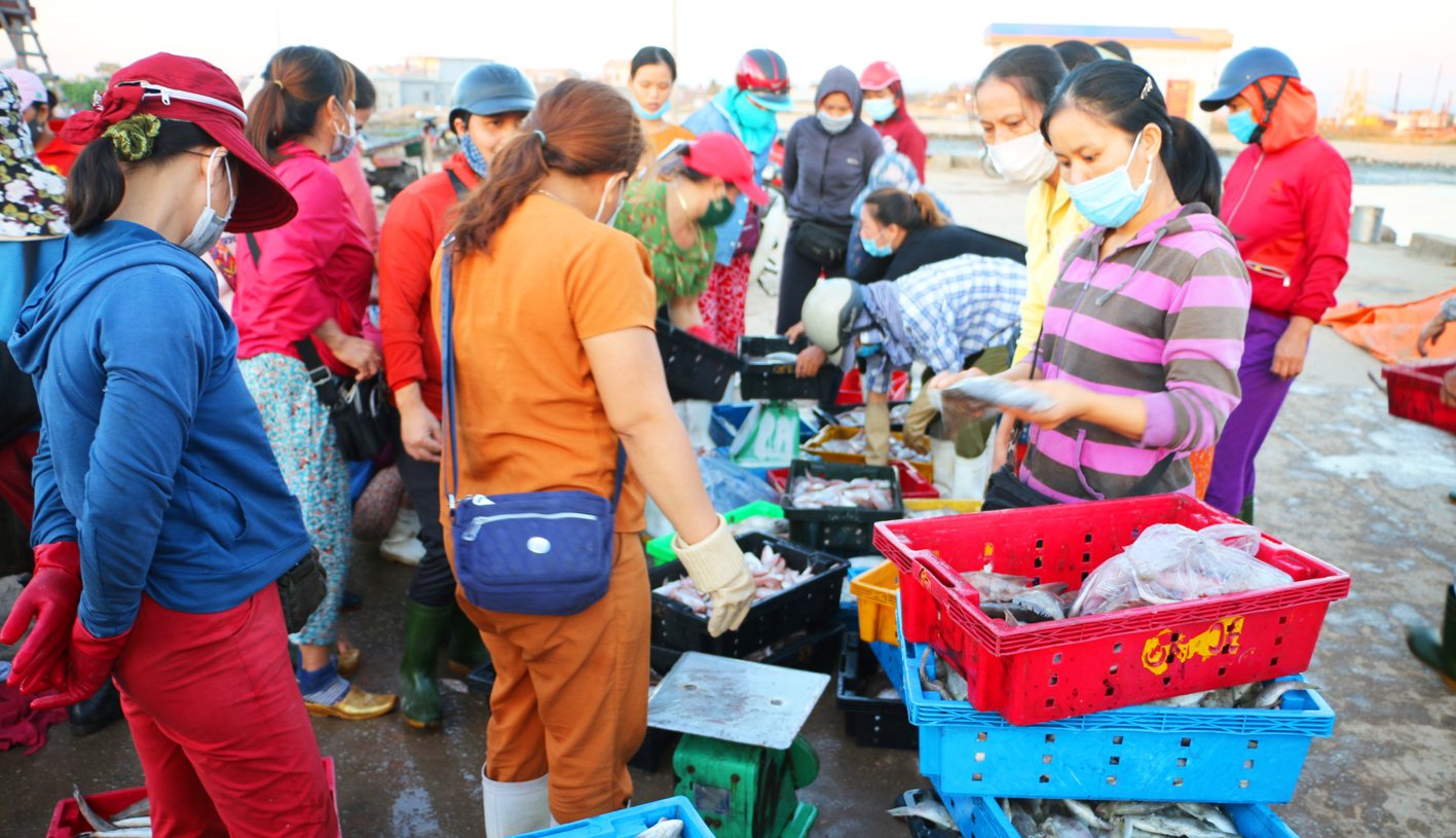 Sau mỗi chuyến đi biển, chị Lê Thị Lép (bìa phải, hàng đầu) còn phải xuống cảng Thuận An bán hải sản cho thương lái - ẢNH: THUẬN HÓA
