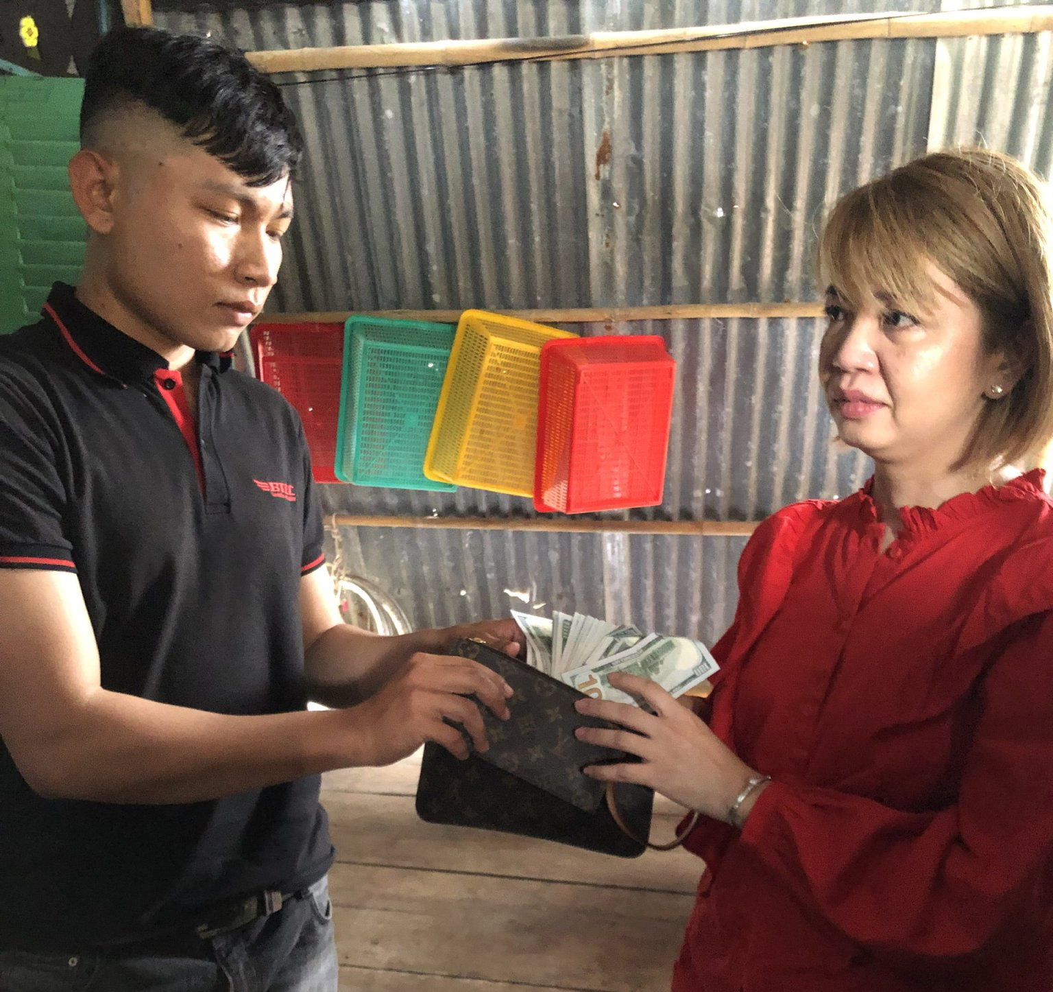 Anh Nguyễn Hiền Phong trả lại chiếc ví có 4.000 USD cho chị Huỳnh Như. Ảnh: CTV.