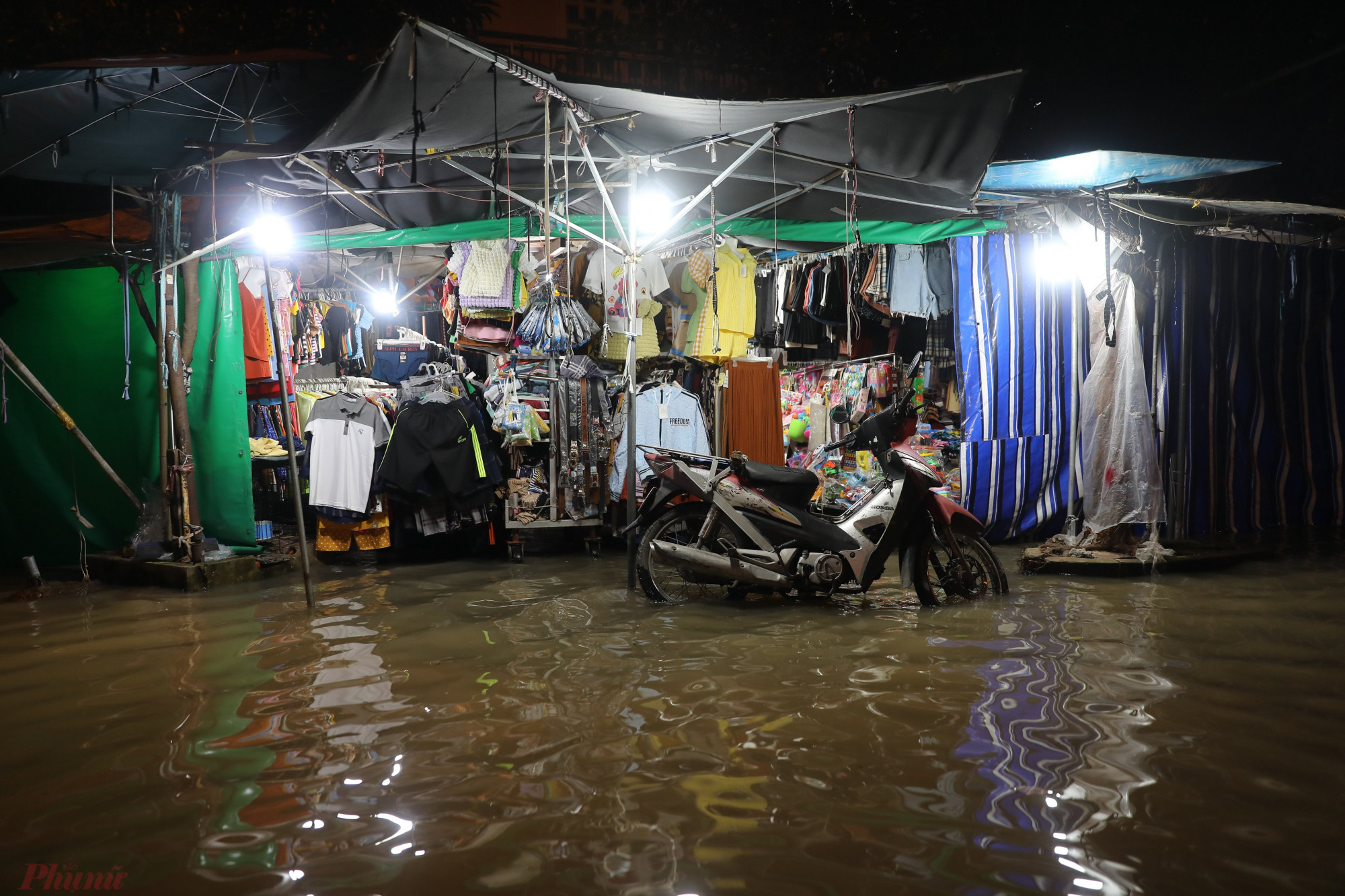 Nước tràn vào bên trong một cửa hàng bán quần áo tại chợ Phú Thuận.