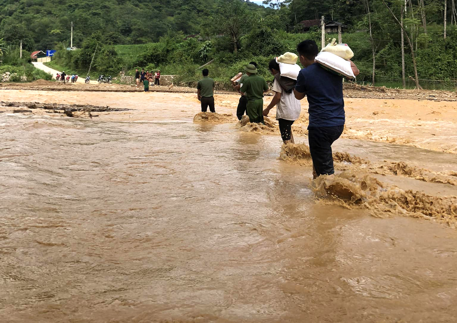 Lực lượng chức năng mang nhu yếu phẩm vào hỗ trợ người dân bị ảnh hưởng do mưa lũ