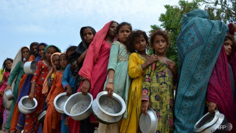 Những người dân bị ảnh hưởng bởi lũ lụt phải xếp hàng chờ nhận thực phẩm tại một trại tập trung tạm bợ ở Sehwan, Pakistan.