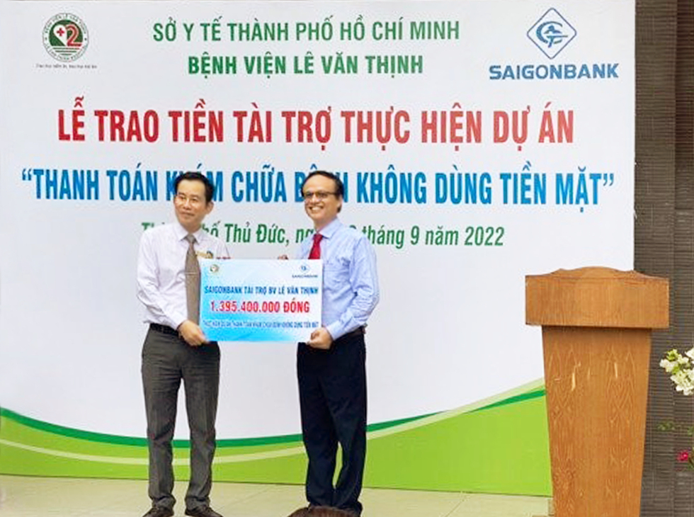 Đại diện SAIGONBANK (phải) trao biểu trưng số tiền tài trợ cho bác sĩ chuyên khoa II Trần Văn Khanh - Giám đốc Bệnh viện Lê Văn Thịnh
