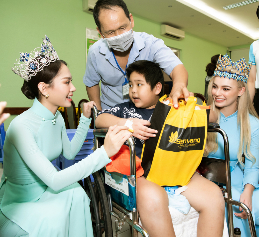 Hoa hậu Mai Phương (trái) và hoa hậu thế giới Karolina Bielawski tặng quà cho trẻ em đang chạy thận tại Bệnh viện Nhi Đồng 2