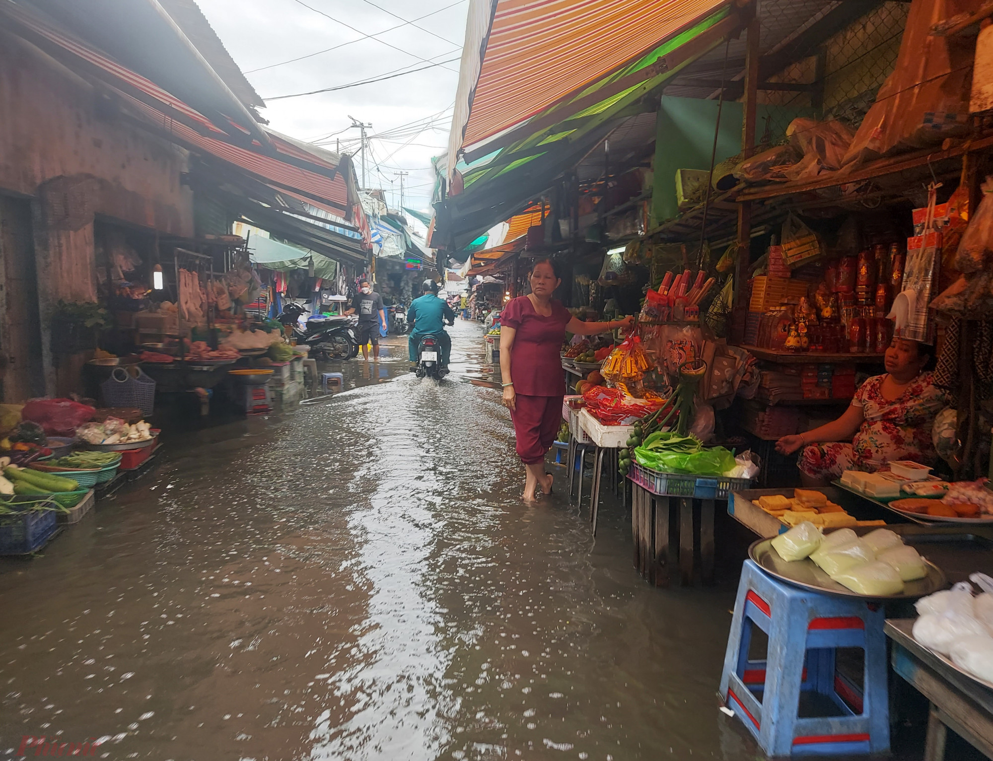 Ở một số vị trí cao hơn, nước ngập ít, tiểu thương bắt ghế kê đồ đạc lên cao để bán tạm. Tuy nhiên, chợ ngập nên rất ít người đến mua hàng.