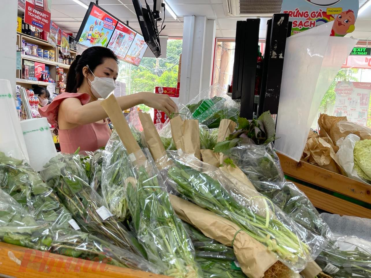Người tiêu dùng chọn mua rau tại một cửa hàng tiện lợi (Ảnh: Nguyễn Cẩm)