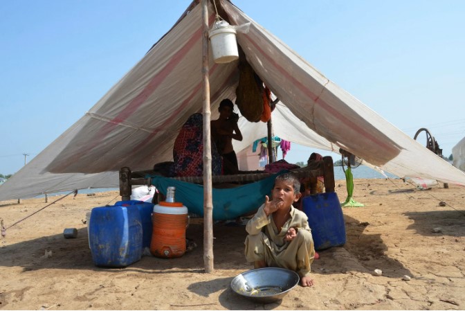 Một gia đình bị ảnh hưởng bởi lũ lụt ngồi trong lều tạm trong một khu trại tạm tại Sohbatpur thuộc quận Jaffarabad vào ngày 19 tháng 9 năm 2022. ẢNH: AFP