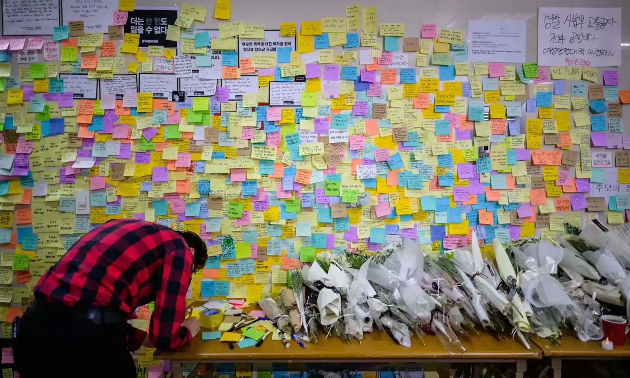 Một người đàn ông viết thư tưởng niệm tại ga Sindang, Seoul, Hàn Quốc, nơi một phụ nữ bị đâm tử vong bởi kẻ theo dõi cô