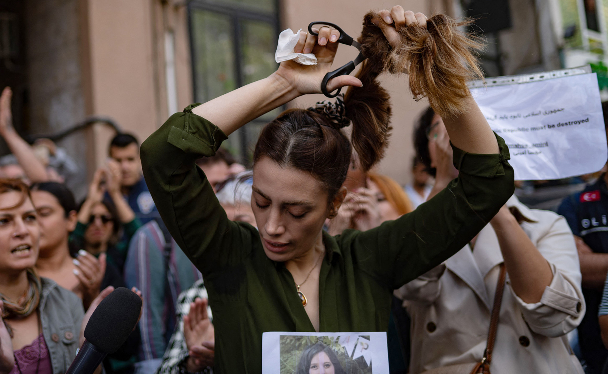 Phụ nữ Iran cắt tóc phản đối các quy định khắt khe về trang phục áp đặt lên phụ nữ nước này - Ảnh: Yasin Akgul/AFP/Getty Images