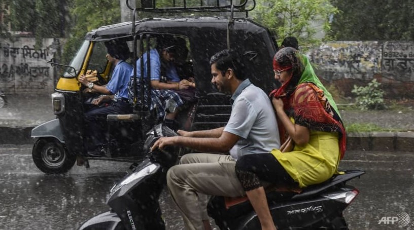 Người đi làm dọc theo con đường trong trận mưa lớn ở Amritsar vào ngày 23 tháng 9 năm 2022. (Ảnh: AFP / Narinder NANU)