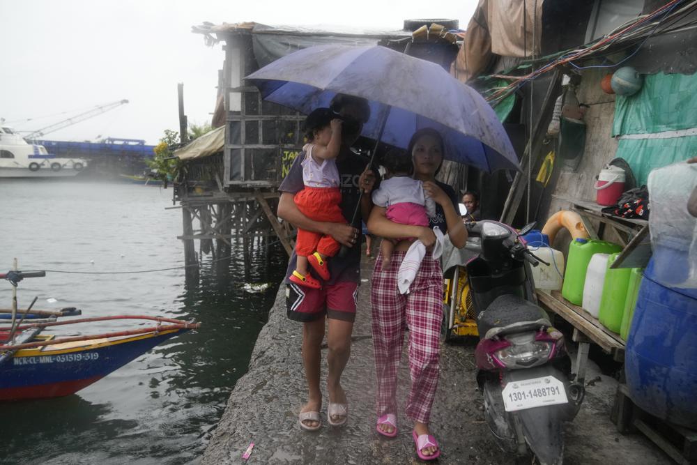 Gia đình bế trẻ nhỏ sơ tán đến khu vực an toàn hơn để chuẩn bị cho sự xuất hiện của Typhoon Noru tại quận khu ổ chuột bên bờ biển Tondo ở Manila, Philippines