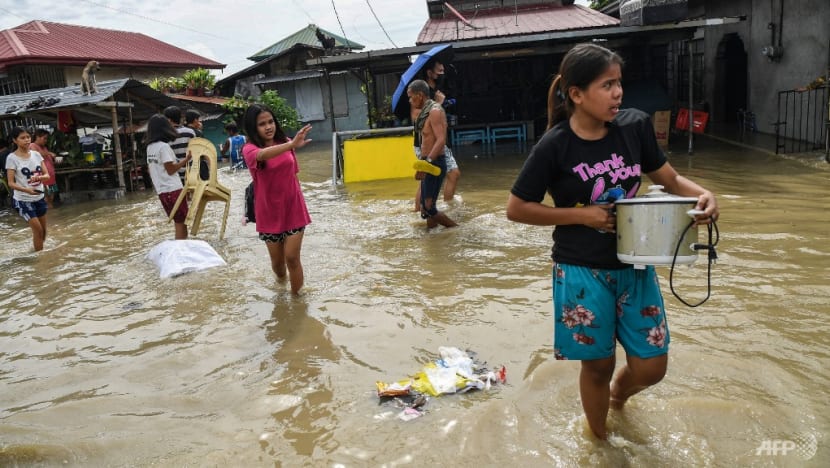 Người dân mang theo đồ đạc trong khi di tản khỏi những ngôi nhà ngập nước sau siêu bão Noru ở San Ildefonso, tỉnh Bulacan