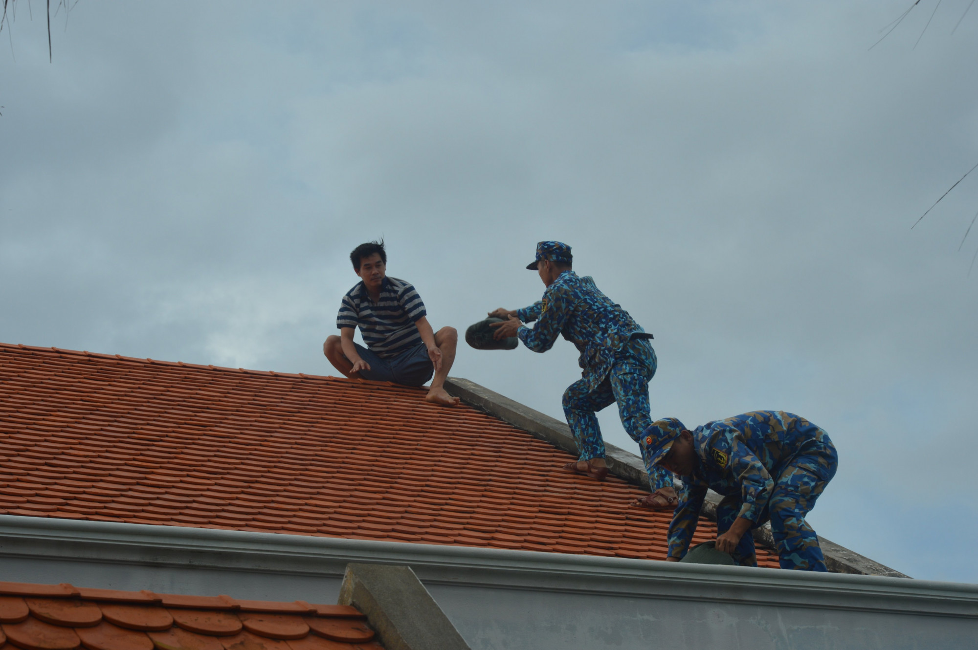 Ngày 26/9, cán bộ, chiến sĩ đảo Sinh Tồn, huyện Trường Sa, tỉnh Khánh Hòa giúp nhân dân chằng buộc mái nhà. 