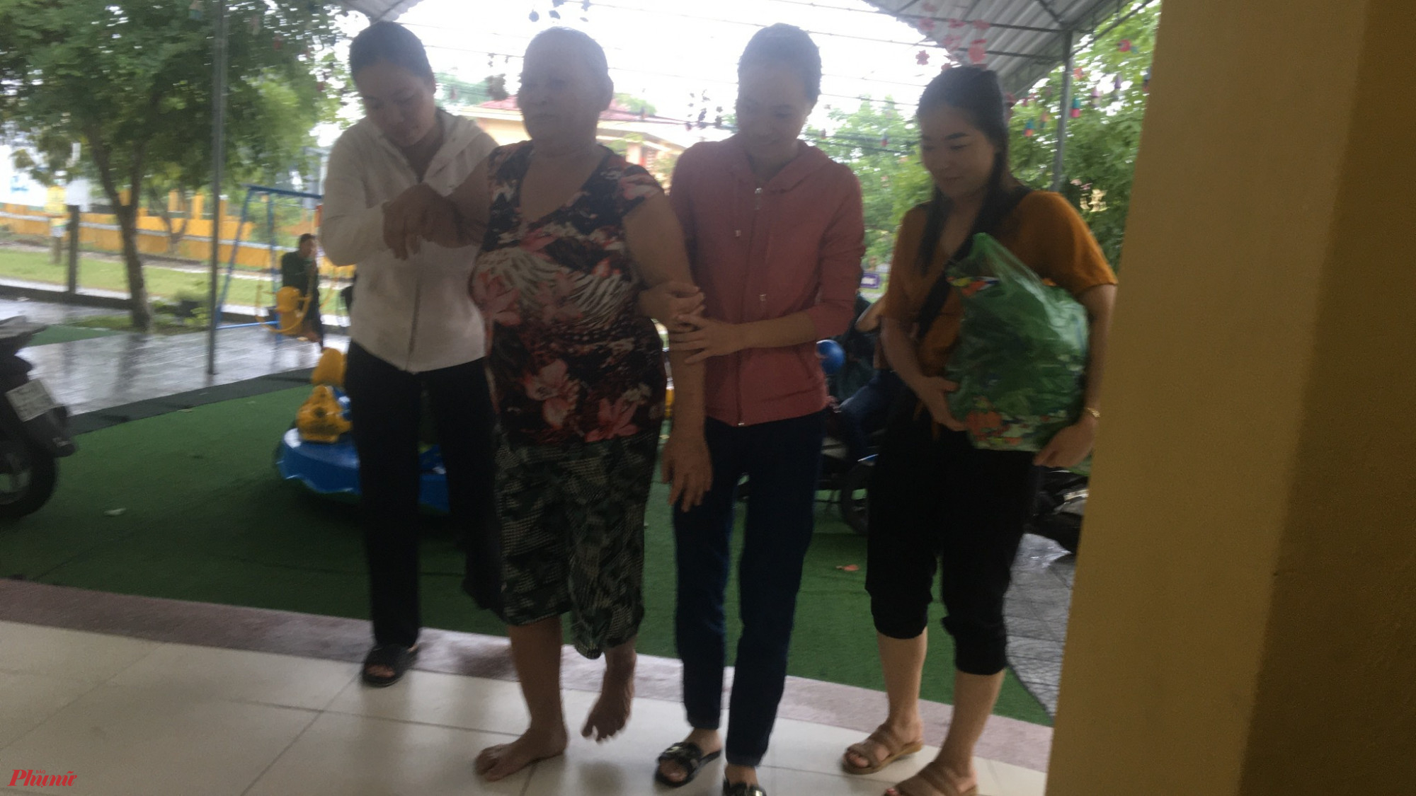 Chị em  Hội viên phụ nữ xã Phú Thuận giúp người già yếu đi tránh trú bão an toàn