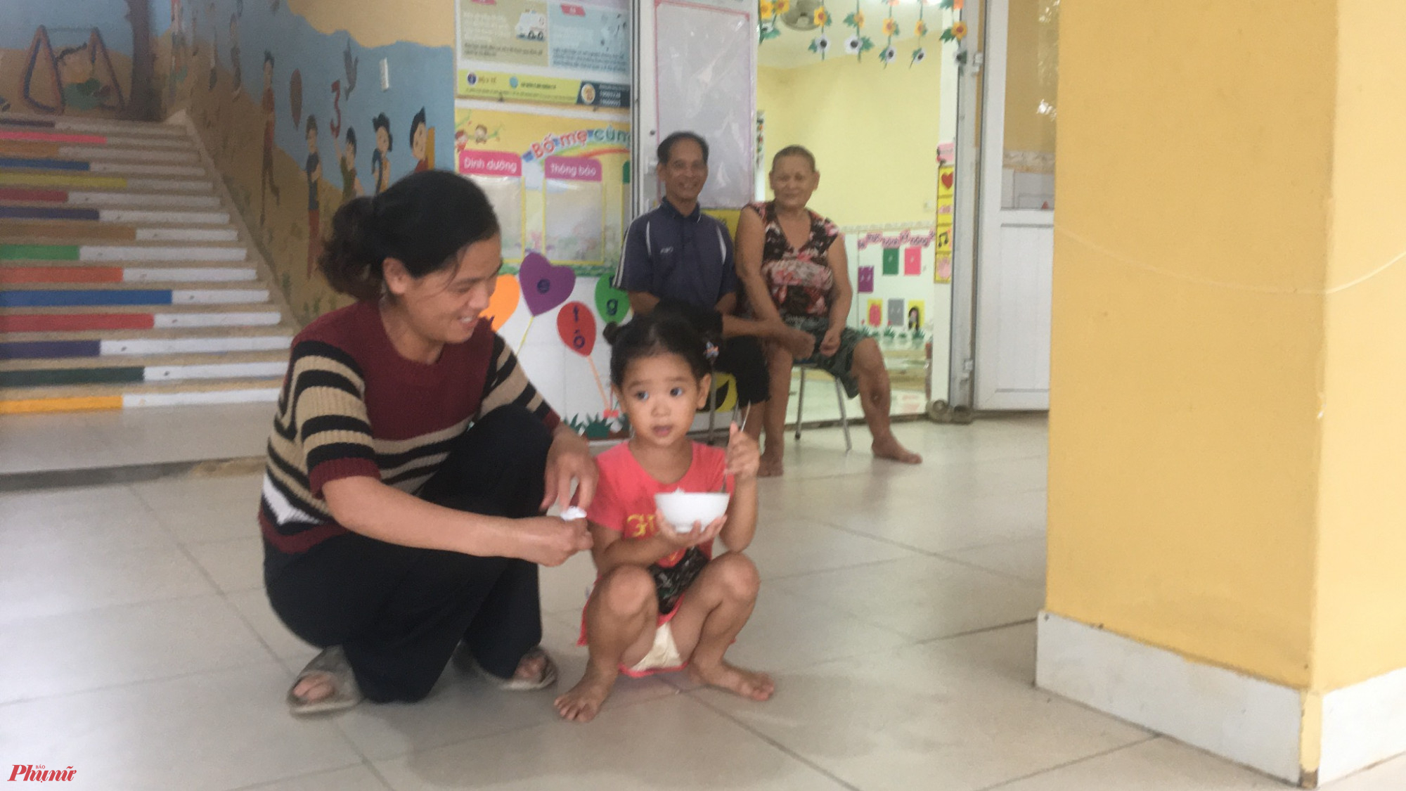 Bà cháu cùng ăn cơm tại Khu tránh trú bão tạm thời ở trường  mầm non xã Phú Thuận