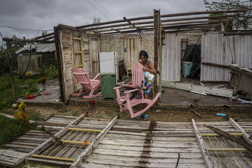 Cư dân Maria Llonch lấy đồ đạc từ ngôi nhà bị hư hại bởi cơn bão Ian ở Pinar del Rio