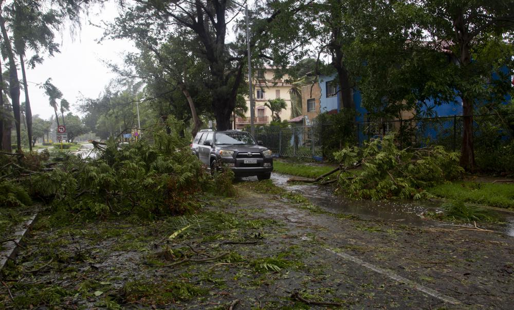 Một chiếc xe len qua những thân cây đổ ngã do gió bão ở Havana