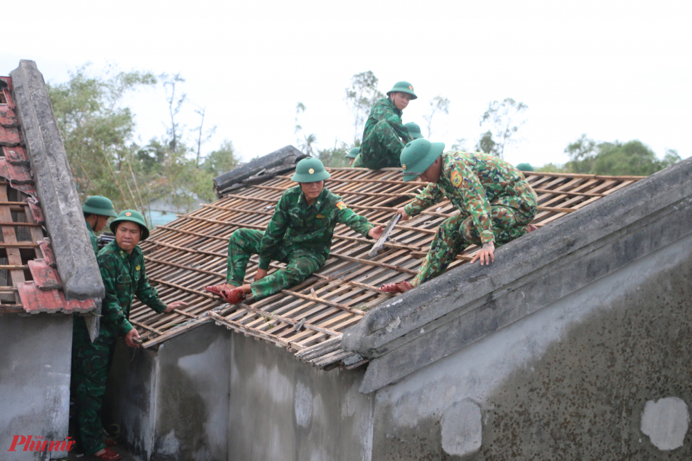Từng tiểu đội được bố trí đến từng hộ gai đình để phụ giúp gia đình vận chuyển ngói lên mái nhà