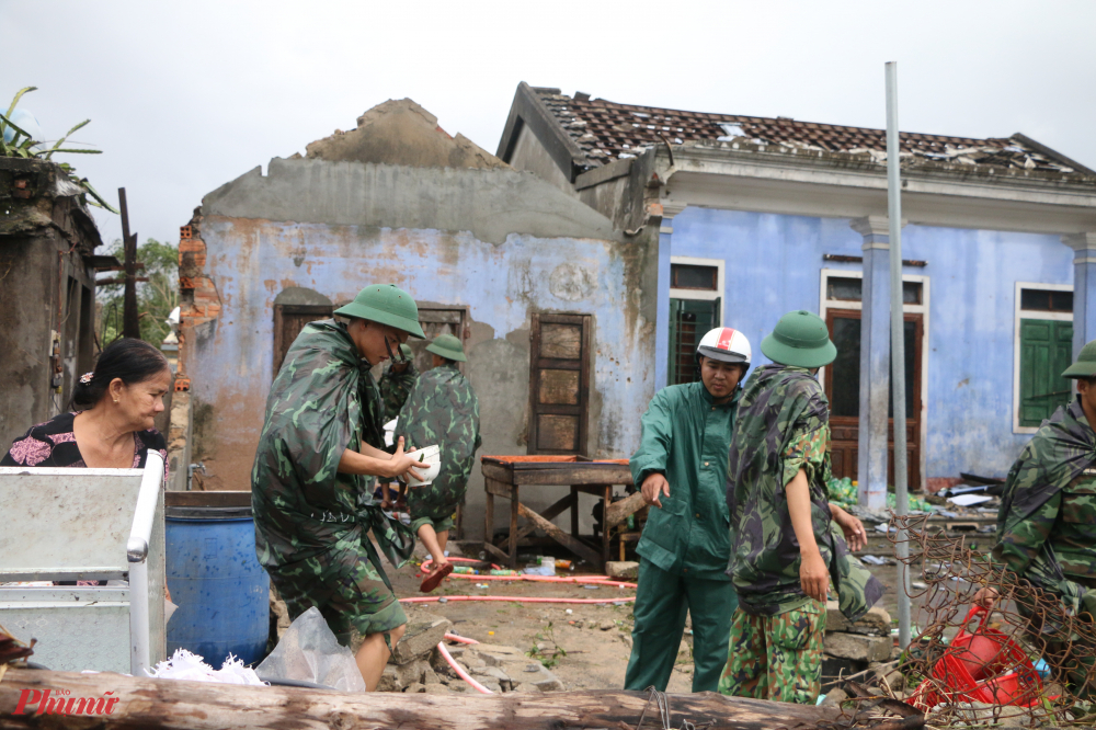 Một số chiến sĩ khác  cùng nhau lợp lại mái nhà,  giúp dân chằng chống nhà cửa sớm ổn định cuộc sống