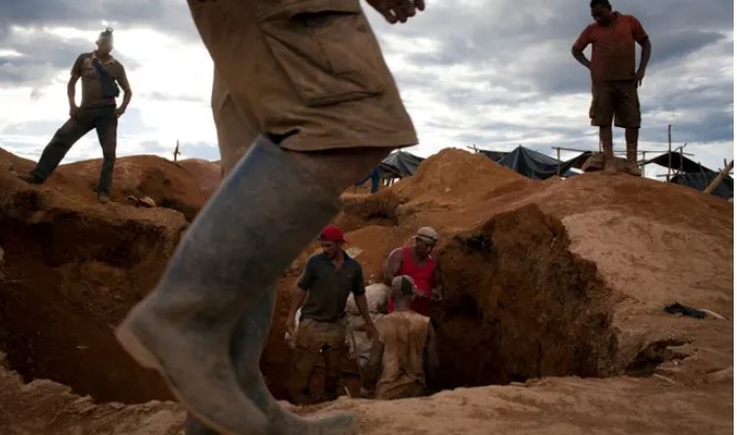 Những người thợ mỏ đào đất để tìm vàng trong một trại tạm bợ để khai thác trái phép gần Tumeremo ở miền nam Bolívar của Venezuela. Ảnh: Carlos García Rawlins / Reuters