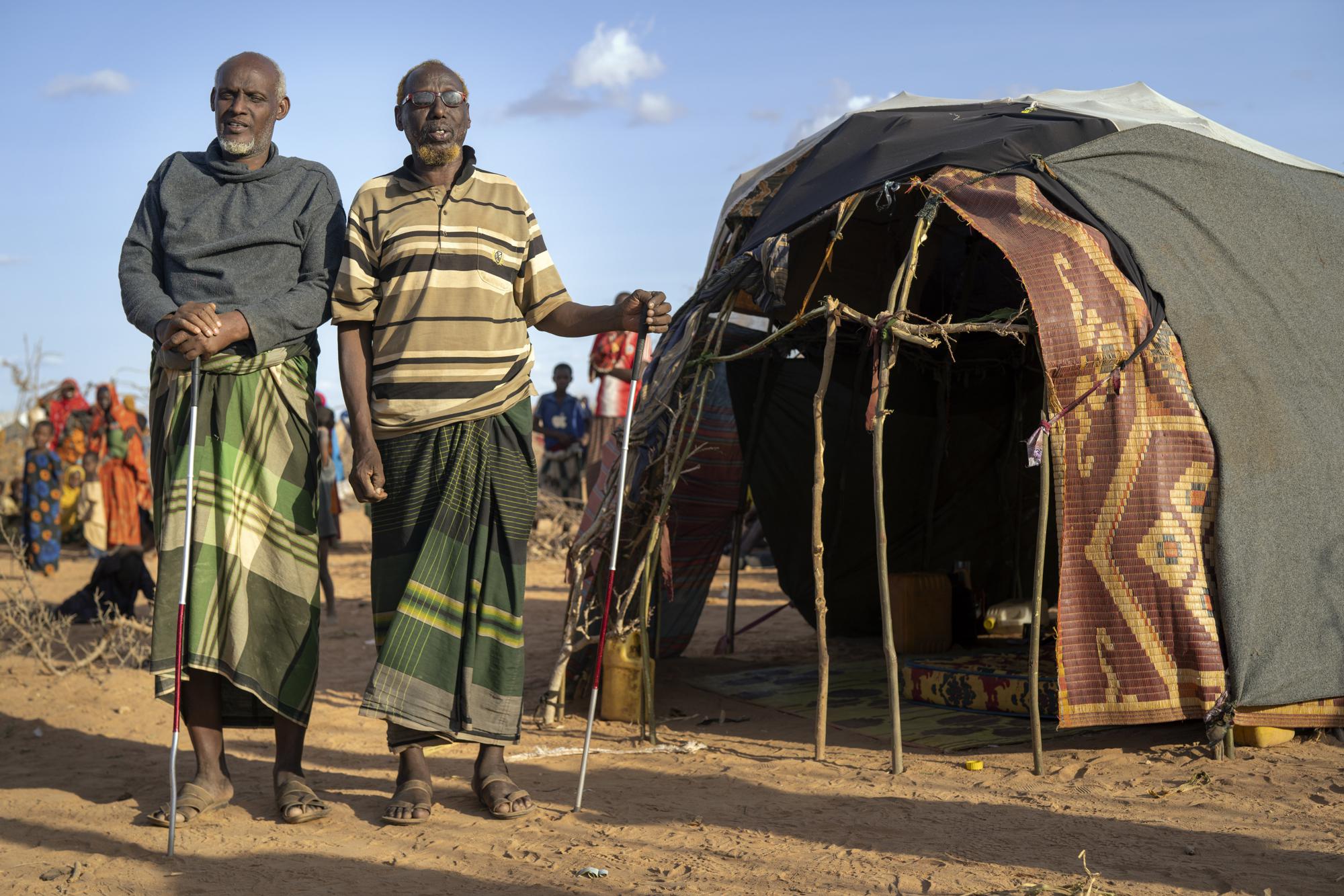 Mohamed Kheir Issack, 80 tuổi (bên phải) và Issack Farow Hassan, 75 tuổi (bên trái) đang đứng trước căn lều tạm bợ ở khu trại tập trung dành cho những người tị nạn đang chạy trốn khỏi Somali - Ảnh: Jerome Delay/AP
