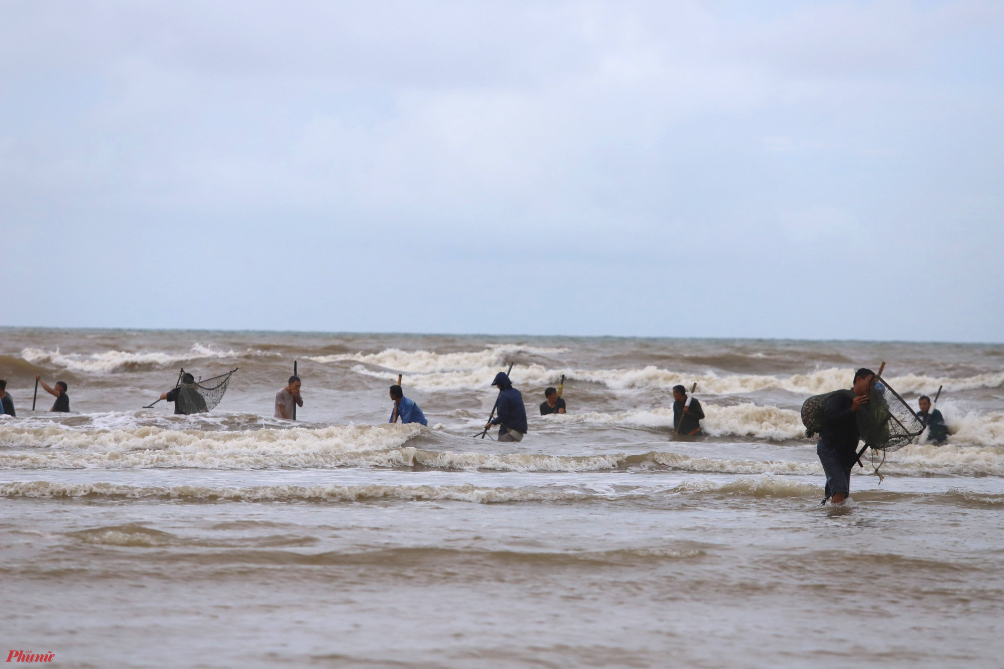 Một số người còn đi ra xa bờ biển để cào sò, bất chấp những con sóng lớn.