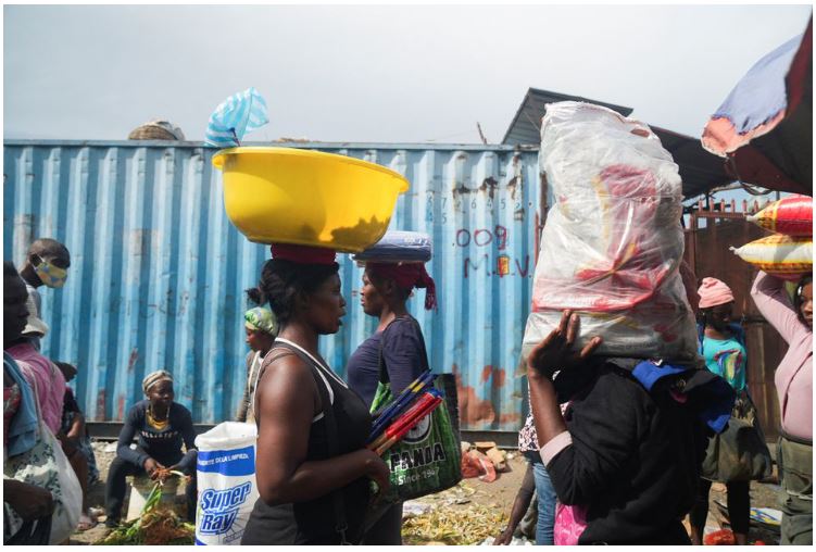 Mọi người tích trữ thực phẩm tại một khu chợ trong bối cảnh thiếu nước, gas nấu ăn và các vật dụng khác.