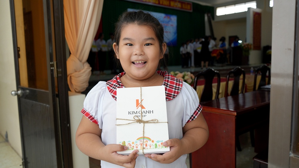 Một em học sinh lớp Hai mừng rỡ khi nhận quà - Ảnh: Kim Oanh Group
