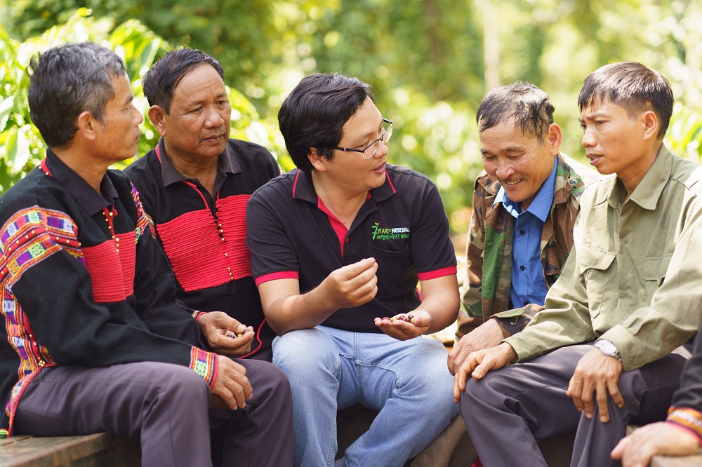 Cán bộ hỗ trợ nông nghiệp của Nestlé Việt Nam chia sẻ kinh nghiệm canh tác cà phê bền vững cho các hộ nông dân tham gia chương trình NCP - Ảnh: Nestlé