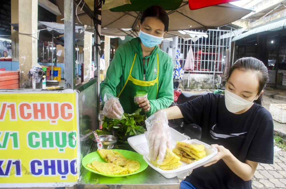 Huỳnh Gia Huyên phụ mẹ bán bún thịt nướng, bánh xèo bằng xe đẩy trong khi chờ ngày học chính thức ở Trường đại học Kinh tế TP.HCM - Ảnh: Phùng Huy
