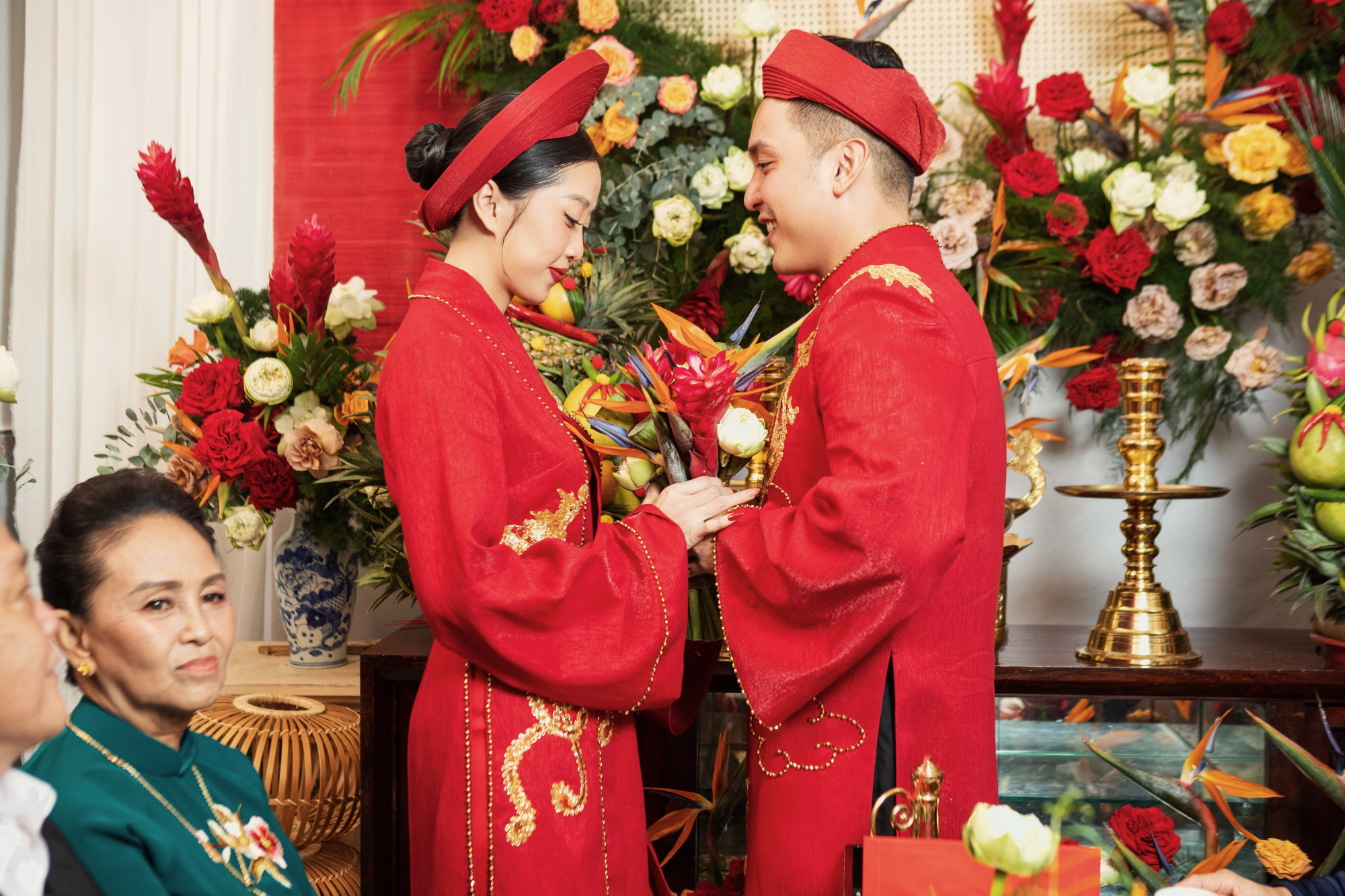 Được biết, trang phục của cô dâu chú rể do đích thân NTK Huỳnh Bảo Toàn may tặng riêng cho 2 vợ chồng. Với điểm nhấn hình ảnh thêu Long Phụng quen thuộc cùng sắc đỏ tượng trung cho điềm may mắn, biểu tượng hạnh phúc càng giúp cặp đôi nổi bật trong ngày.