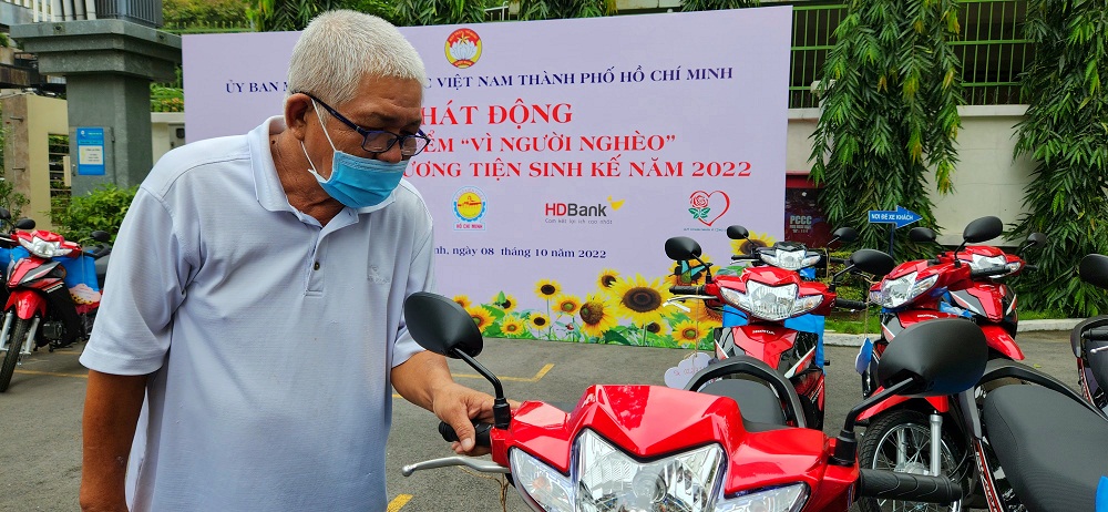 Ông Nguyễn Quốc Trạng  (78 tuổi, quận Tân Phú), lái xe ôm, xúc động bên phương tiện mới vừa được hỗ trợ tại Tháng cao điểm “Vì người nghèo” 2022 - Ảnh: HDBank
