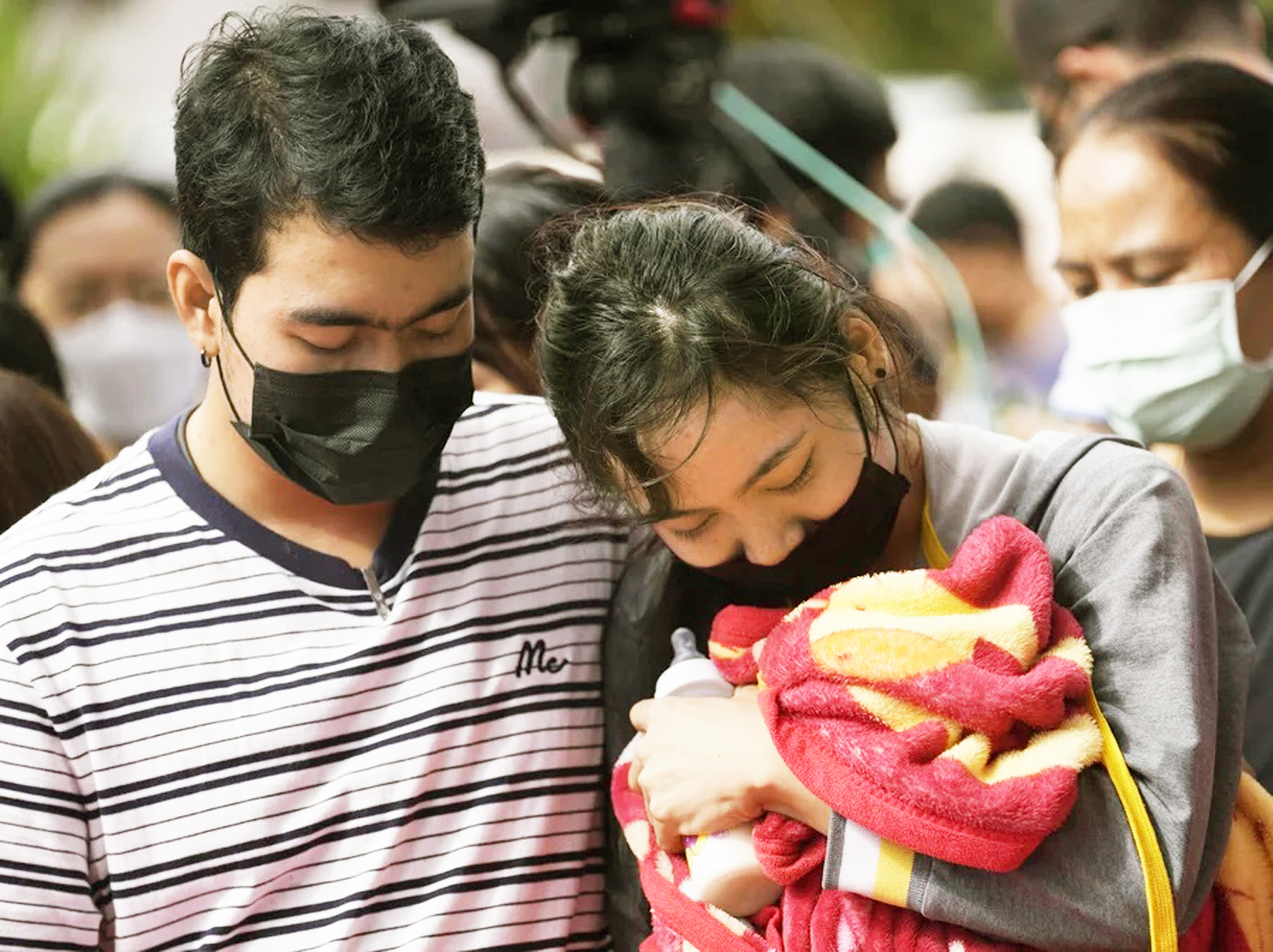 Một gia đình mang theo chăn và bình sữa đến buổi lễ cầu nguyện cho những nạn nhân của vụ tấn công vào trung tâm chăm sóc trẻ ở thị trấn Uthai Sawan, Thái Lan - ẢNH: AP