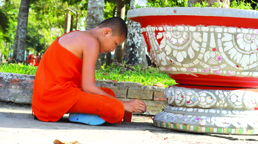 Một vị sư đang trang trí chậu bông của chùa