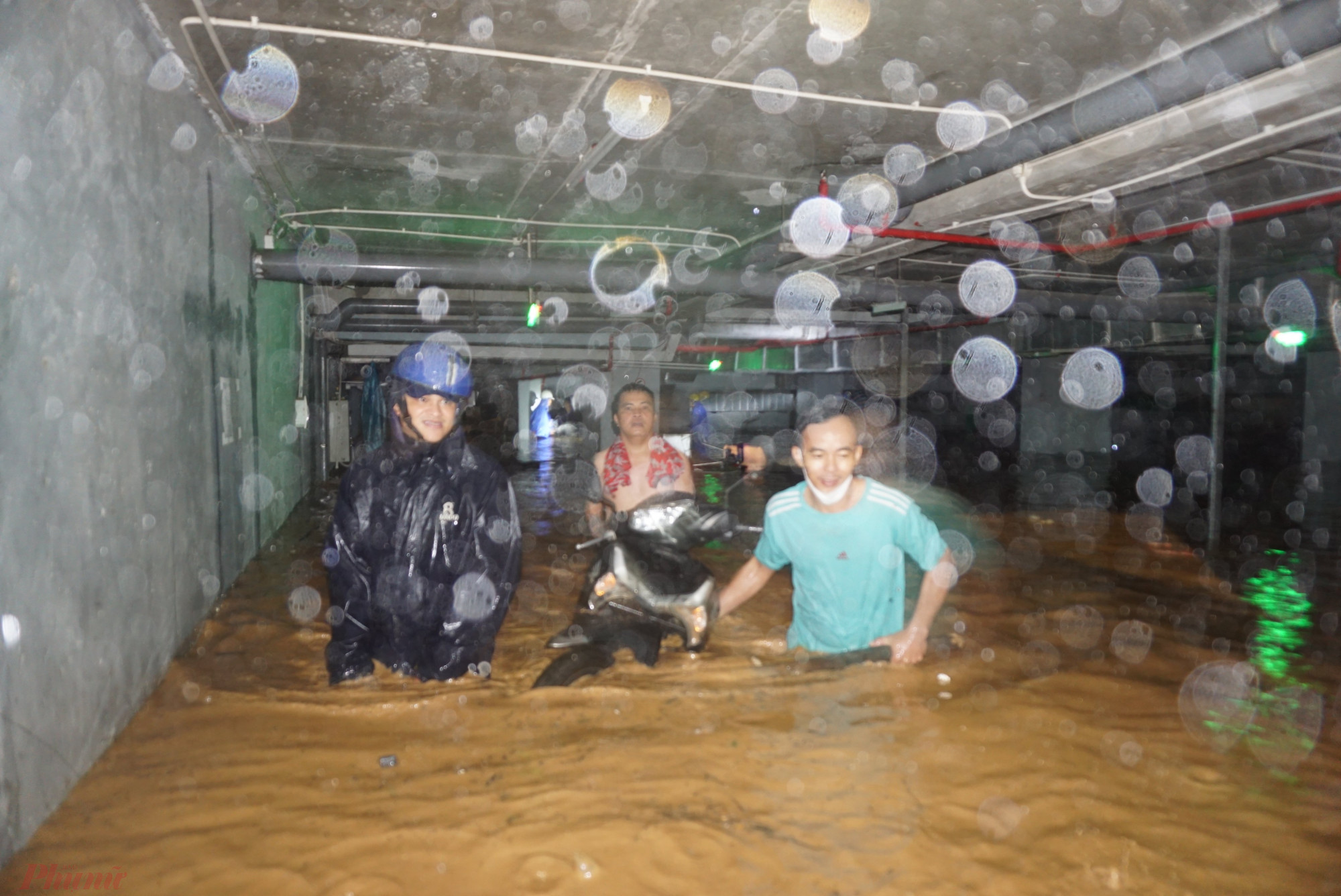 Người dân ở chung cư Hòa Khánh (Q.Liên Chiểu) đưa xe ra khỏi tầng hầm đang bị nước tràn vào