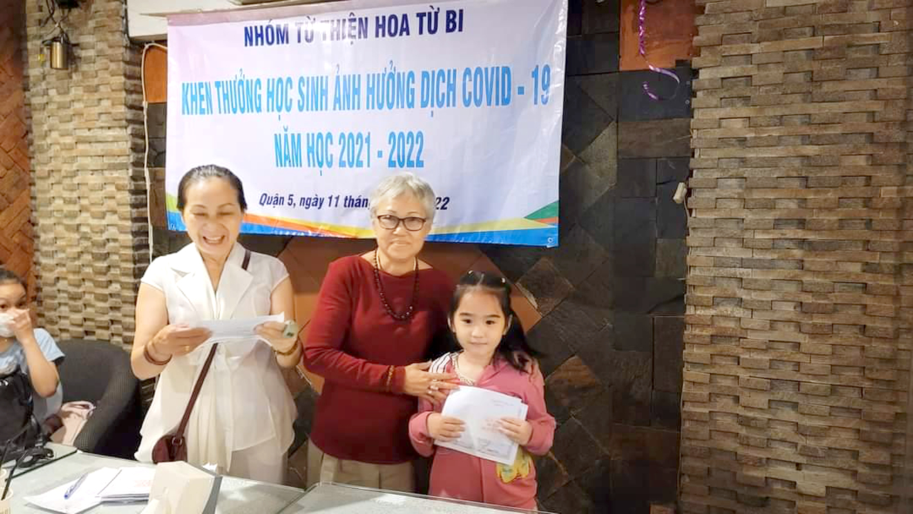 Chị Nguyễn Vũ Song Hòa (bìa trái) khen thưởng những học sinh vươn lên học giỏi dù bị ảnh hưởng dịch COVID-19