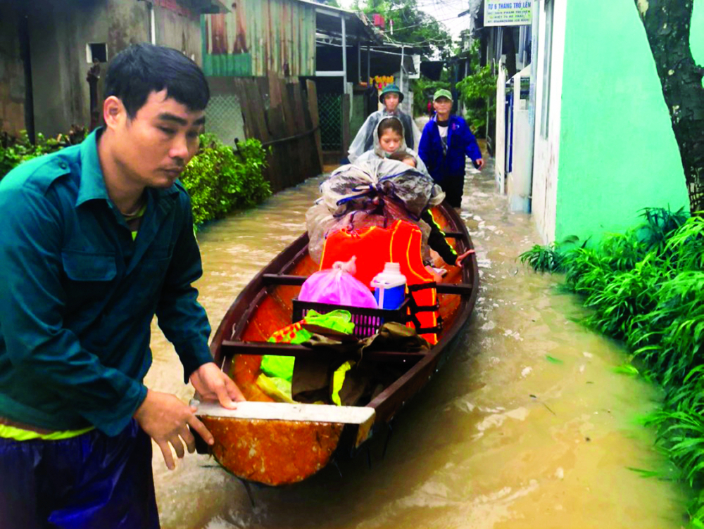 Lực lượng dân quân tự vệ P.Kim Long, TP.Huế hỗ trợ thai phụ chuyển dạ đến cơ sở y tế an toàn trong ngày mưa lũ - ẢNH: THUẬN HÓA