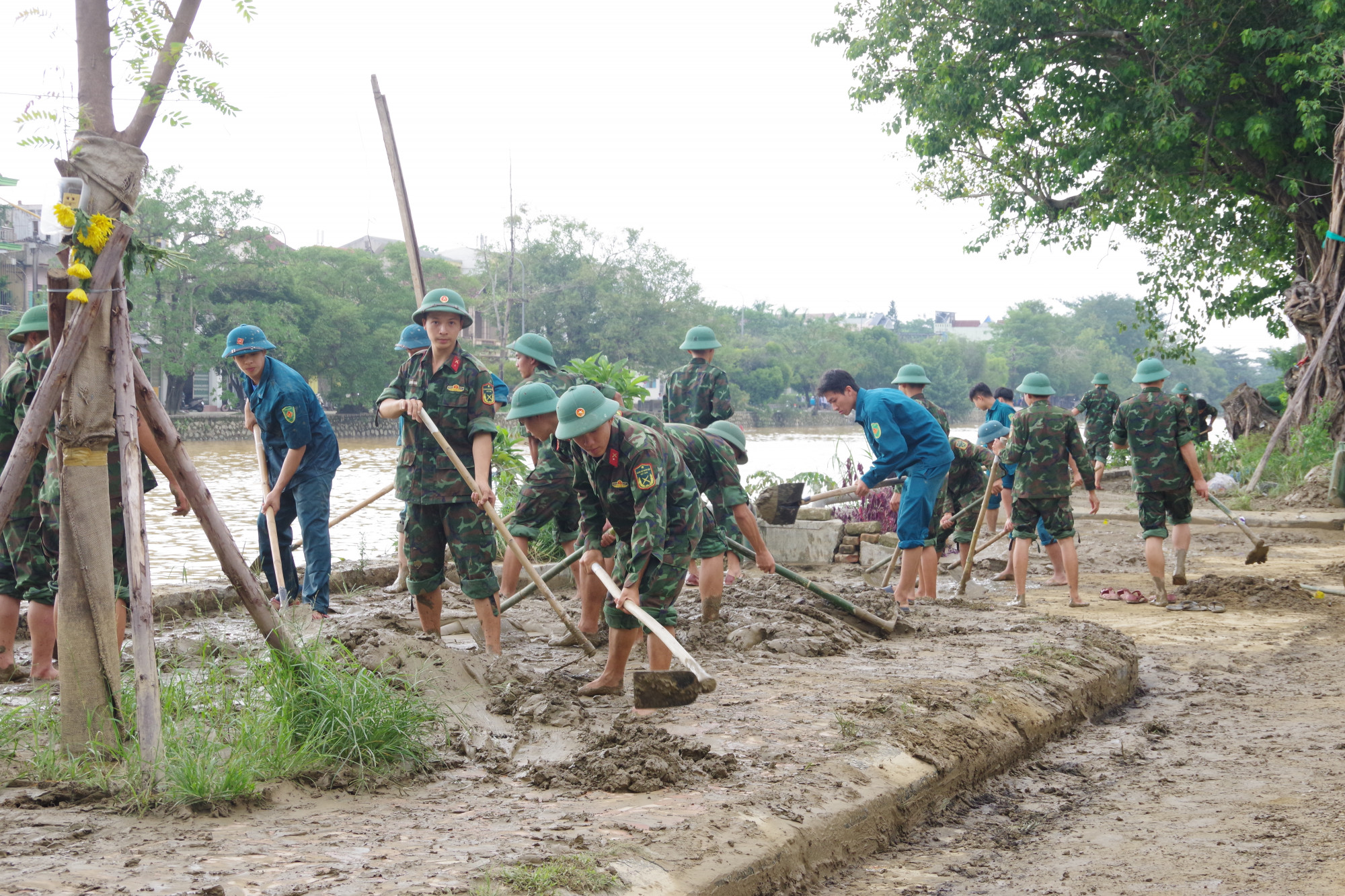 Lực lượng bộ đội, dân quân làm tham gia dọn vệ sinh sau khi nước lũ rút