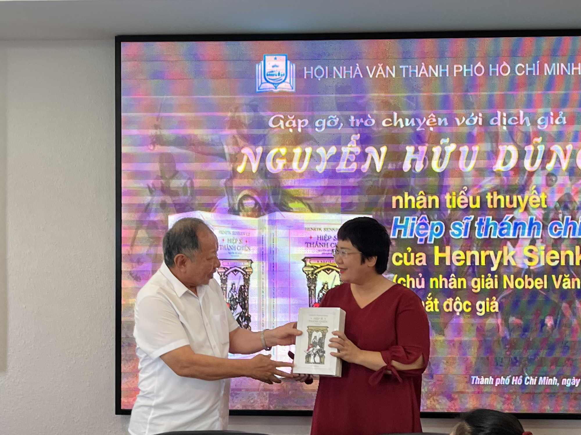Dịch giả Nguyễn Hữu Dũng (trái) trao tặng bộ sách cho bà Nguyễn Lệ Chi, Giám đốc Chibooks, đại dịch Hội đồng Văn học dịch-Hội Nhà văn TPHCM