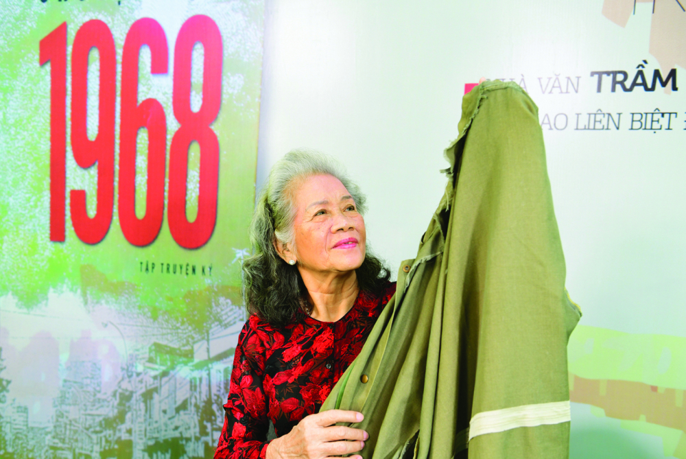 Bà Lại Thị Kim Túy xúc động khi nhắc về kỷ vật quý giá, là chiếc áo mà đồng đội đã tặng năm xưa  ẢNH: NGUYỄN QUANG