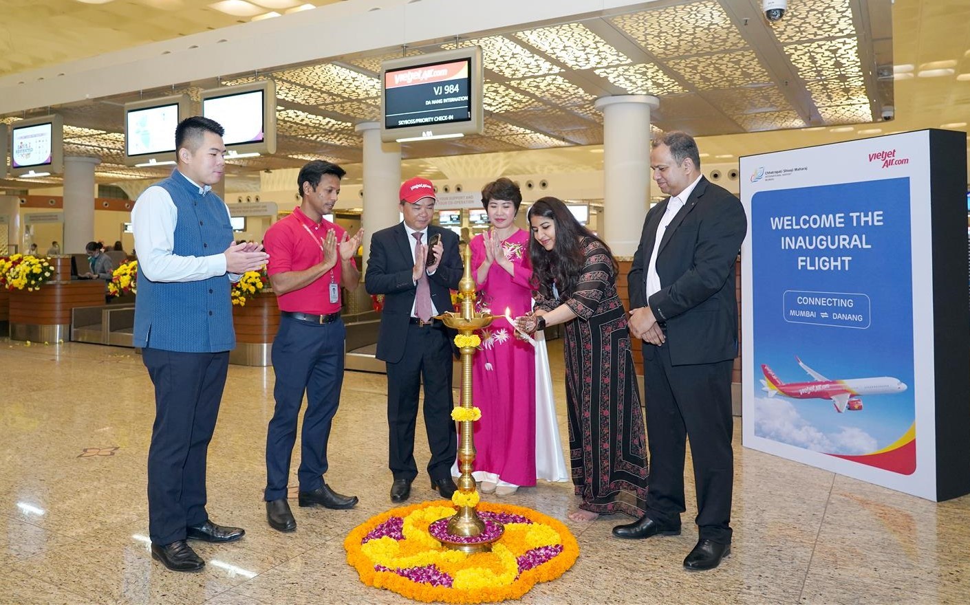 Nghi thức chào mừng và tặng hoa hành khách trên chuyến bay đầu tiên kết nối thành phố Mumbai với TP. Đà Nẵng - Ảnh: Tài Nguyên