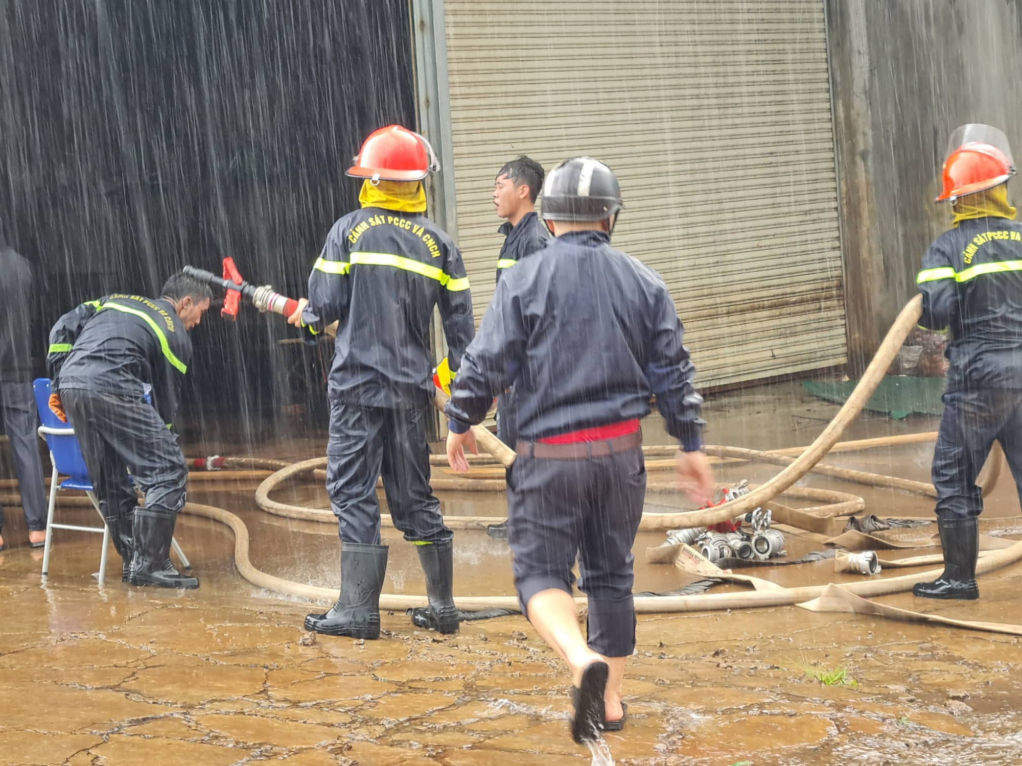 Dưới trời mưa tầm tã, các chiến sĩ cứu nạn cứu hộ vẫn thầm lặng tìm cách khống chế lửa