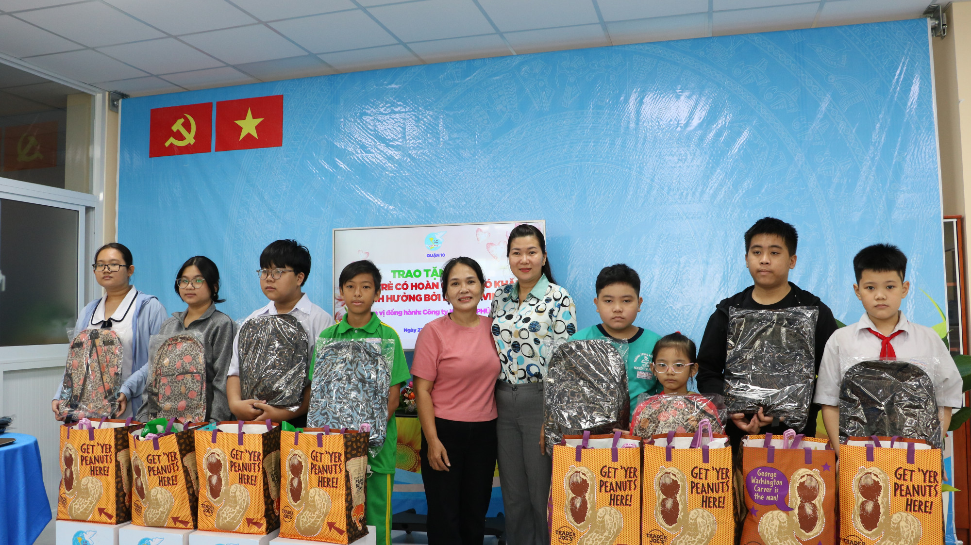 Bà Lê Thị Thu Hồng - Chủ tịch Hội LHPN Q.10 và bà Hà Thị Thu Dung - Giám đốc Công ty Khang Phúc Gia (thứ năm từ trái qua) trao tặng quà cho các em