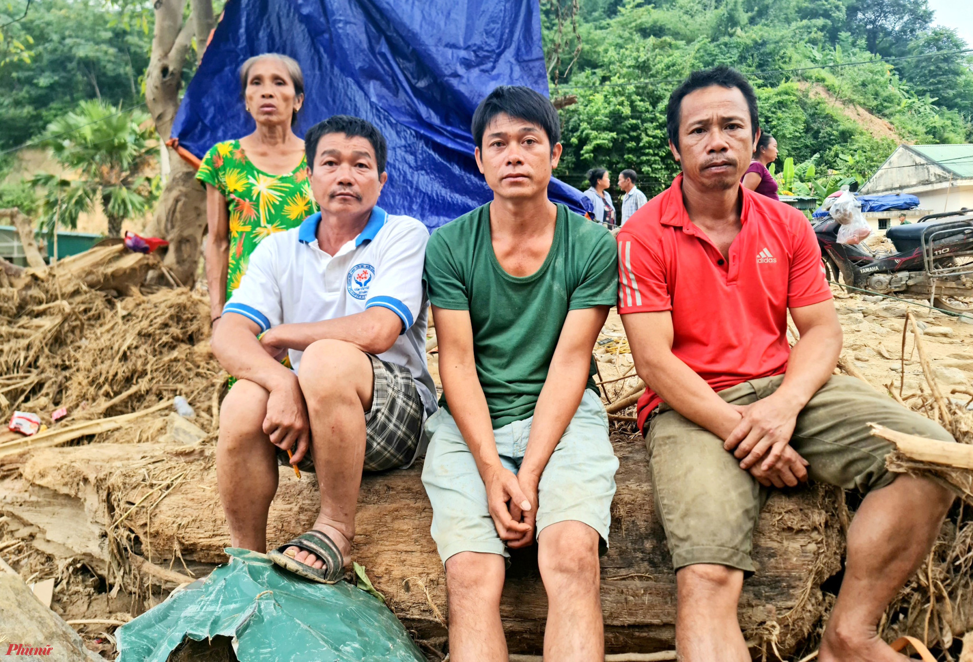Anh Vông (áo xanh ở giữa) cùng 2 người trong bản nhớ lại giây phút phá cửa cứu hàng chục người mắc kẹt trong lũ - Ảnh: Phan Ngọc