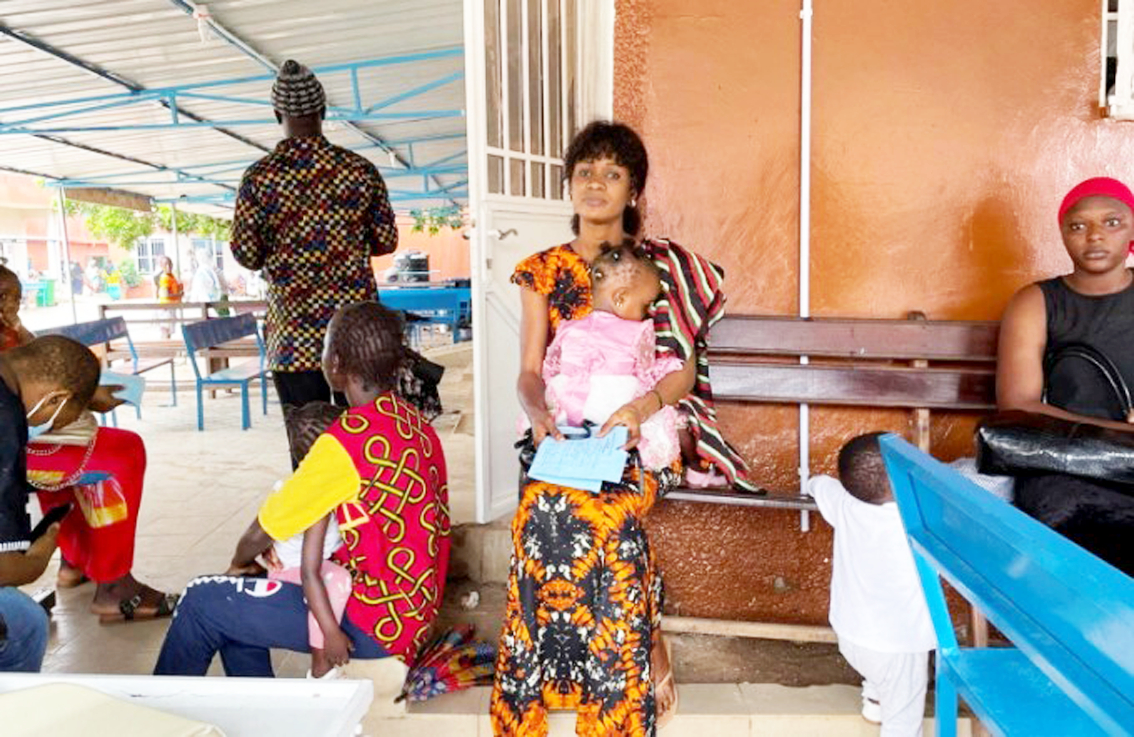 Một phụ nữ đang đưa con gái đi khám tại bệnh viện ở Bundung, Gambia - ẢNH: REUTERS