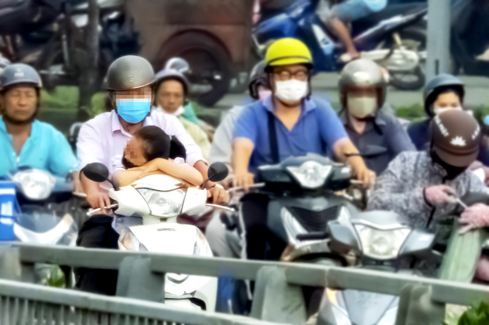 Trẻ ngủ gật trên đường đến trường (ảnh chụp trên đường Nguyễn Trãi, Q.5, TP.HCM sáng 25/10) - Ảnh: Phùng Huy