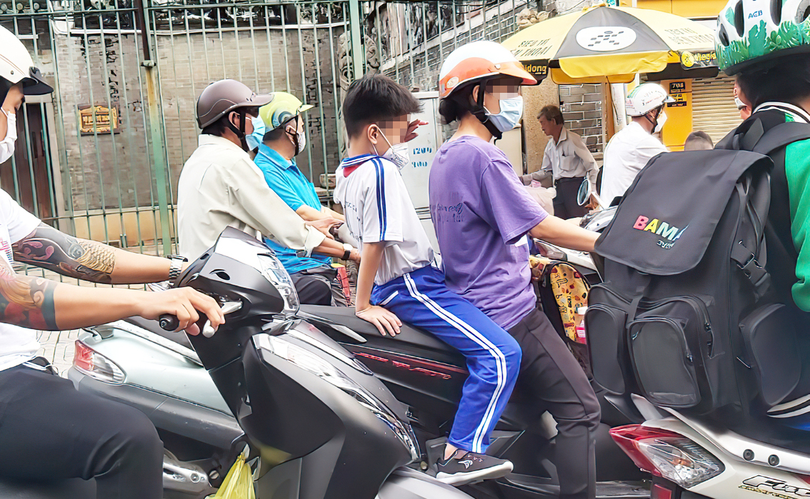 Buổi sáng, rất dễ bắt gặp cảnh trẻ mệt mỏi, ngủ gật trên đường đến trường (ảnh chụp trên đường Nguyễn Trãi, Q.5, TP.HCM) - ẢNH: PHÙNG HUY